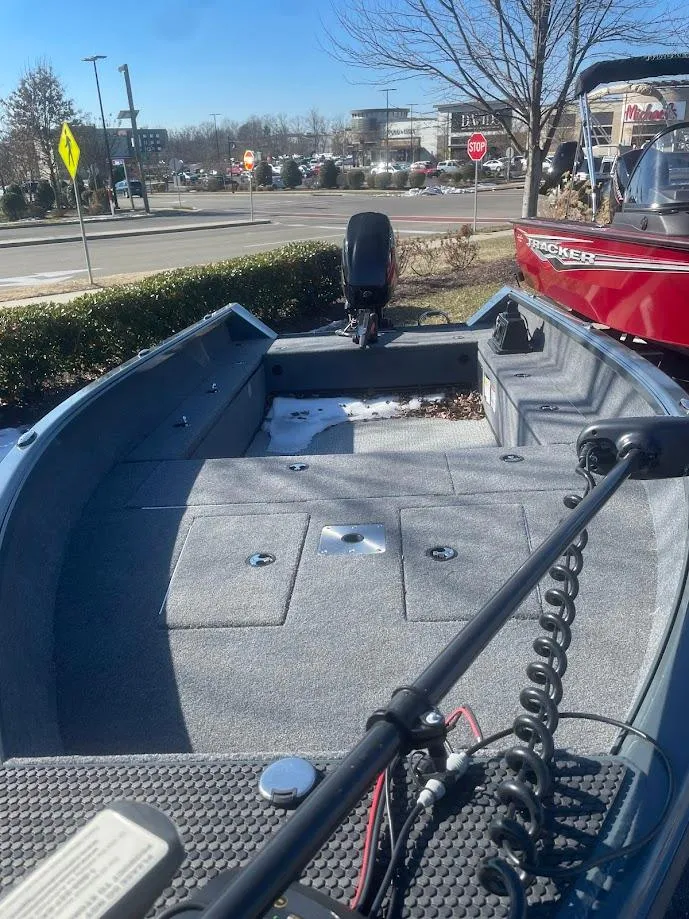 Slide: The Image of 2024 Ranger VS1665T boat with gray interior, parked outdoors near a road. - 1