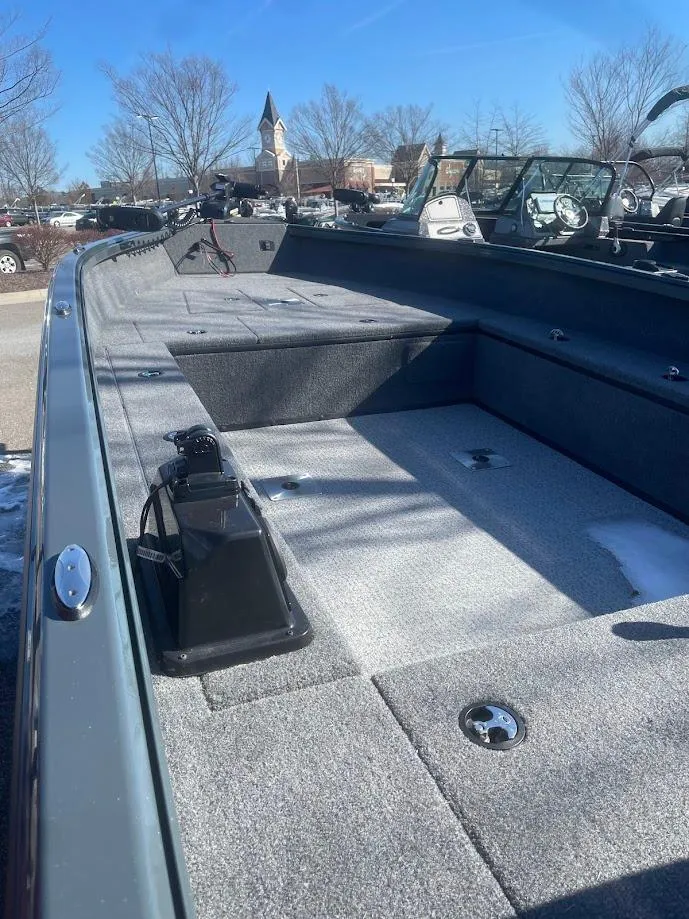 Slide: The Image of 2024 Ranger VS1665T boat interior with gray carpet and storage compartments. - 2