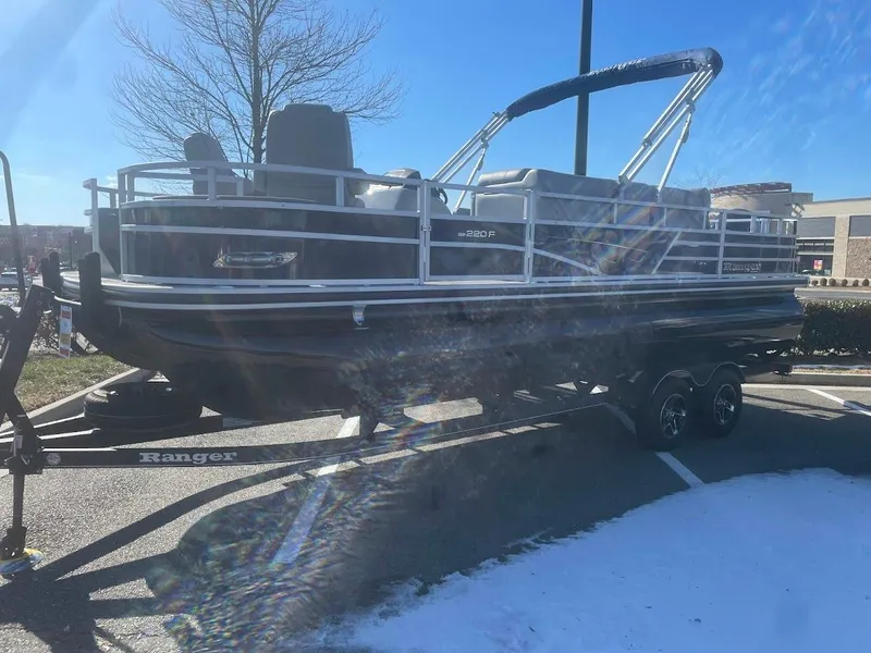 The Image of 2024 Ranger Reata 220F pontoon boat on trailer in parking lot. - 0