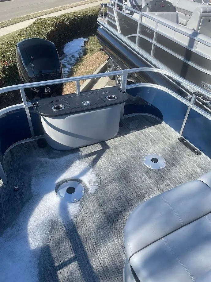 Slide: The Image of 2024 Ranger Reata 220F boat deck with seating and motor, docked outdoors. - 3