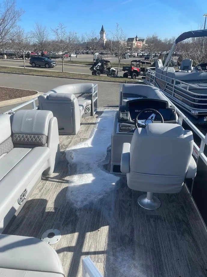 Slide: The Image of 2024 Ranger Reata 223C pontoon boat interior with seating and steering console. - 4