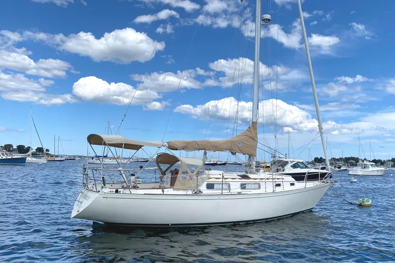 The Image of 1981 Sabre 34 sailboat on calm water under a blue sky with clouds. - 0