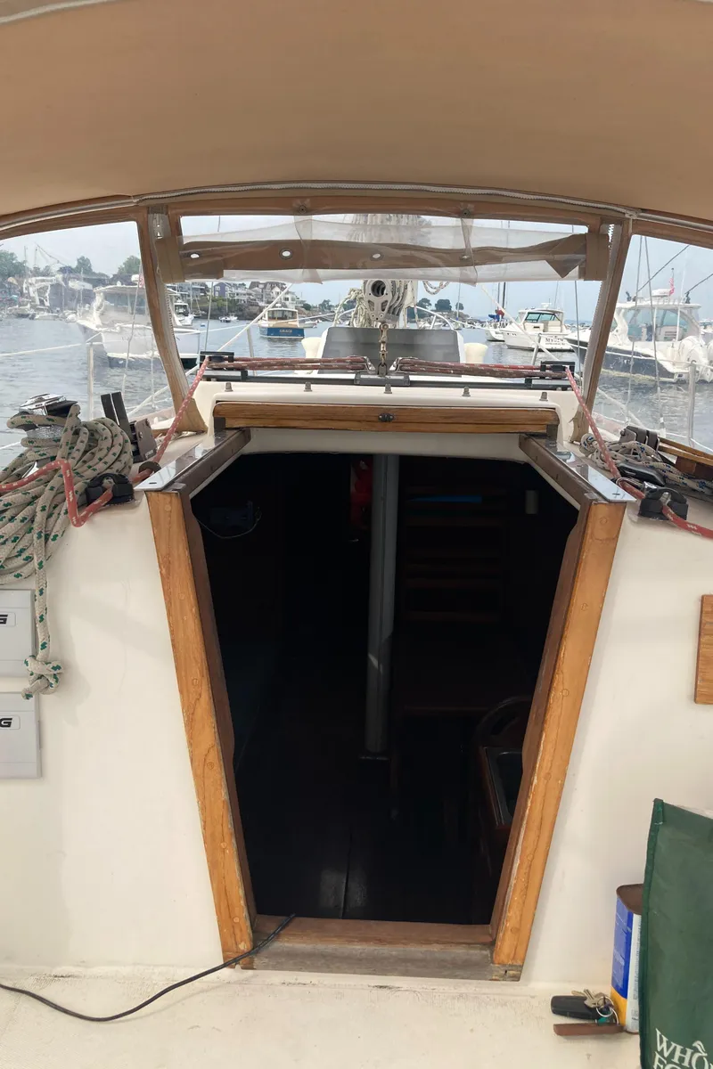 Slide: The Image of 1981 Sabre 34 sailboat cockpit with open cabin entrance, docked at marina. - 10