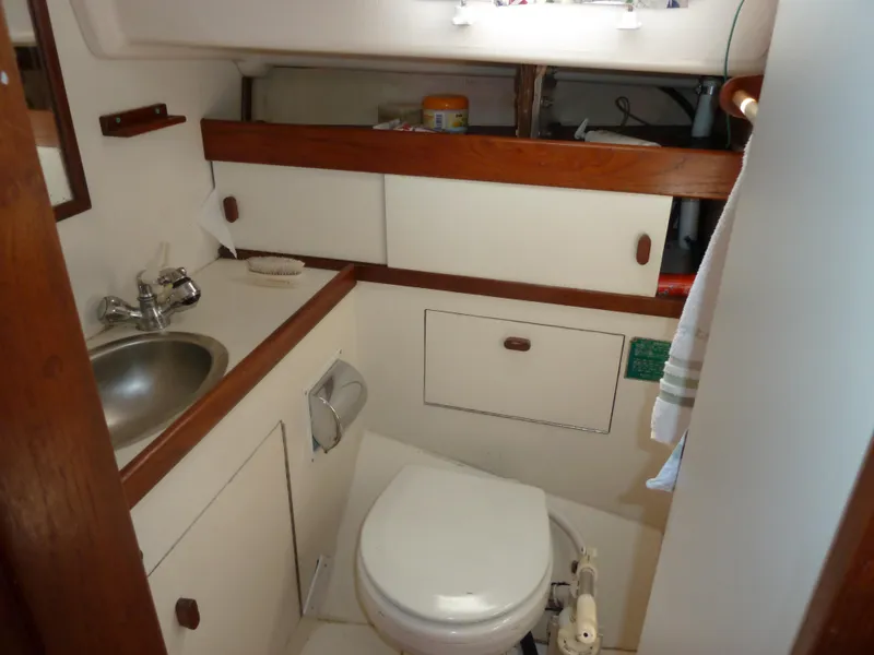 Slide: The Image of 1981 Sabre 34 yacht bathroom with sink, toilet, and wooden cabinetry. - 15