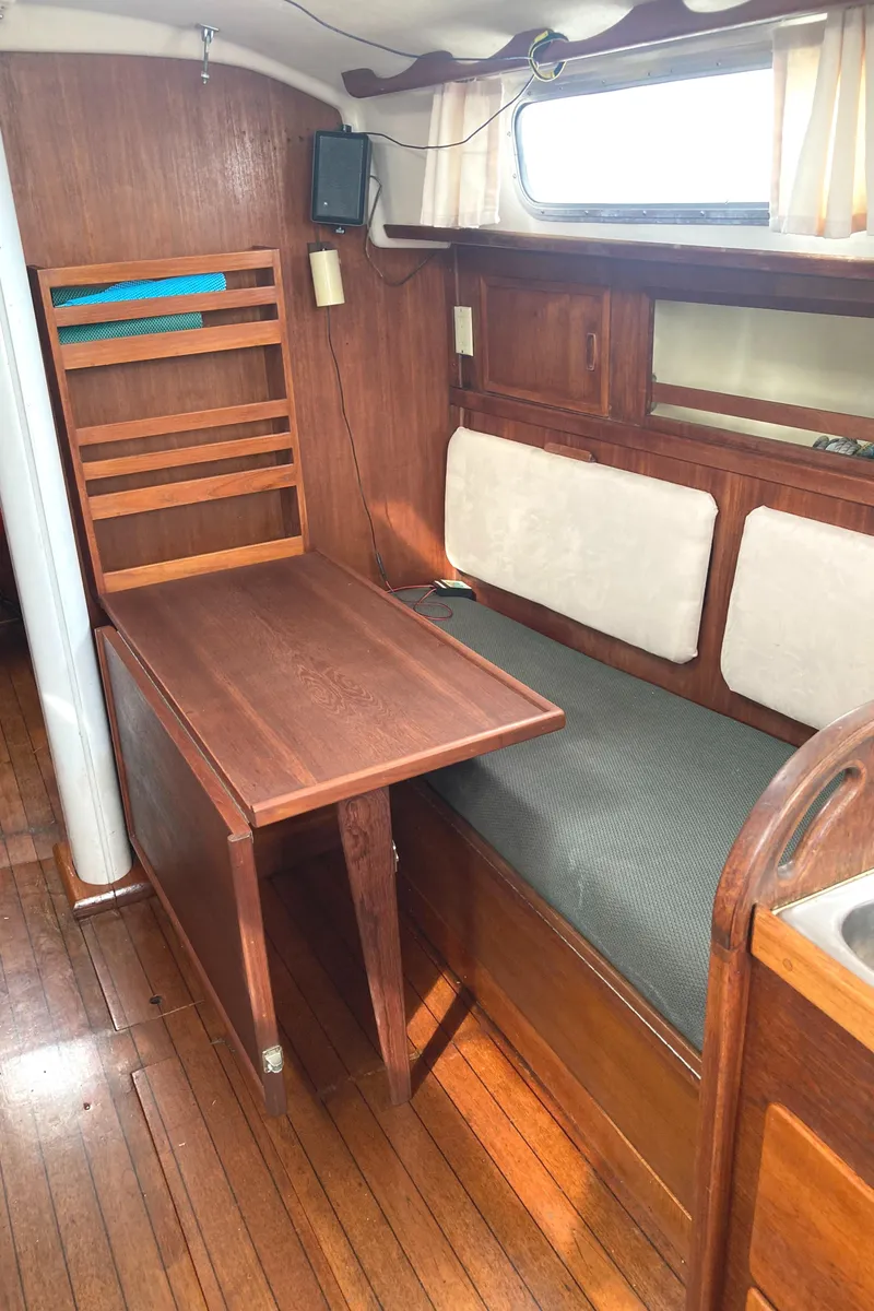 Slide: The Image of 1981 Sabre 34 sailboat interior with wooden table and seating area. - 26