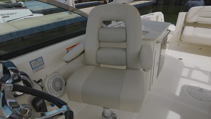 Slide: The Image of 2014 Boston Whaler 270 Vantage boat interior with plush captain's chair and steering wheel. - 8