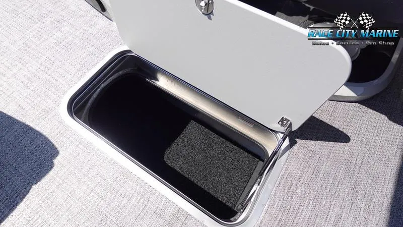 Slide: The Image of Open storage compartment on 2025 Barletta C24QC boat, featuring carpeted interior. - 23