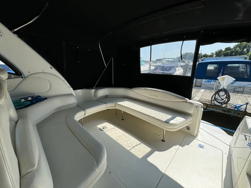 Slide: The Image of 1999 Sea Ray 380 Sundancer interior with white seating and large windows. - 10