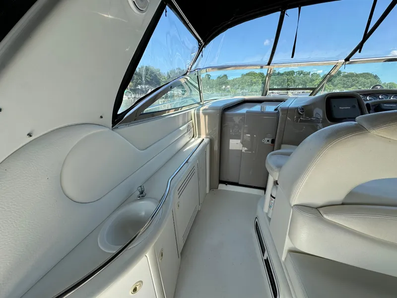 Slide: The Image of 1999 Sea Ray 380 Sundancer cockpit with beige seating and helm, featuring a sleek design. - 12