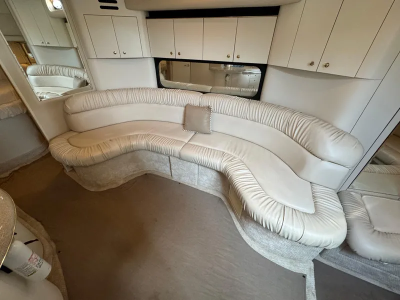 Slide: The Image of Luxurious interior of 1999 Sea Ray 380 Sundancer with curved white leather seating. - 19