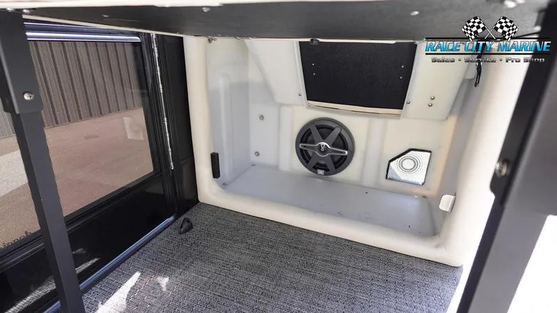 Slide: The Image of Interior storage compartment of 2025 Barletta L25M boat with speaker and carpeted floor. - 39
