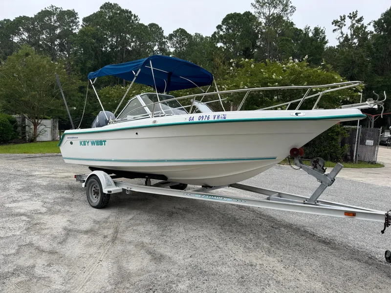 The Image of Key West 1900 Dual Console boat on trailer, 2000 model, with blue canopy. - 1