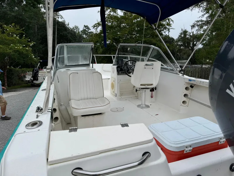 Slide: The Image of 2000 Key West 1900 Dual Console boat with seating and canopy, parked outdoors. - 8