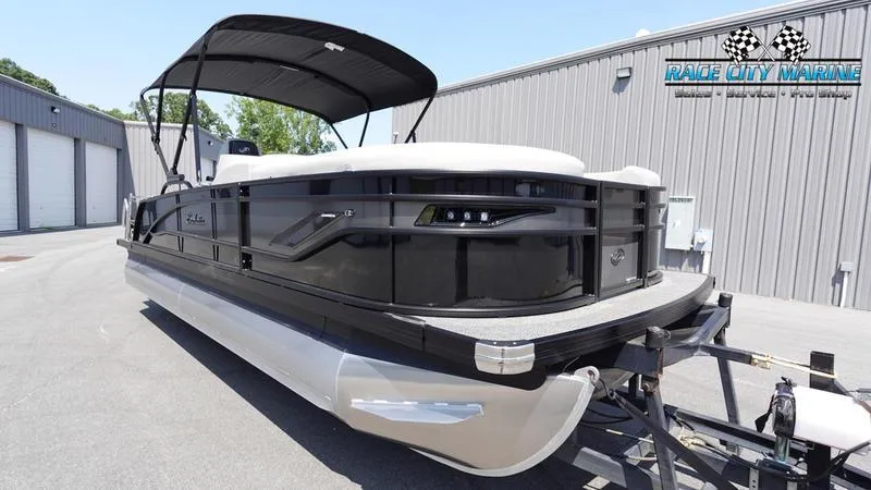 Slide: The Image of 2025 Barletta X23UC pontoon boat on trailer, parked outside Race City Marine. - 3