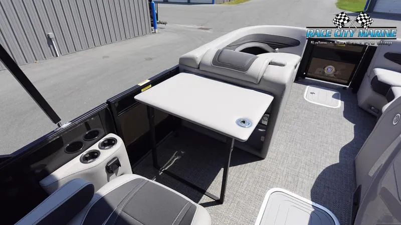 Slide: The Image of 2025 Barletta X23UC boat interior with seating, table, and cup holders. - 30