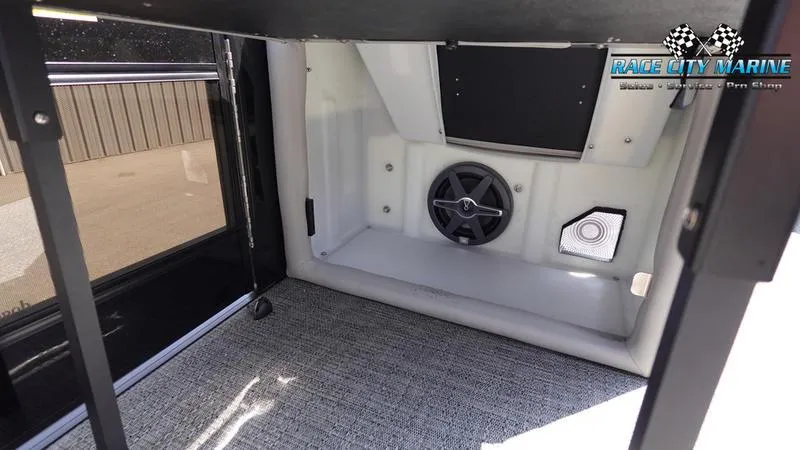 Slide: The Image of 2025 Barletta X23UC interior storage compartment with speaker and carpeted flooring. - 31