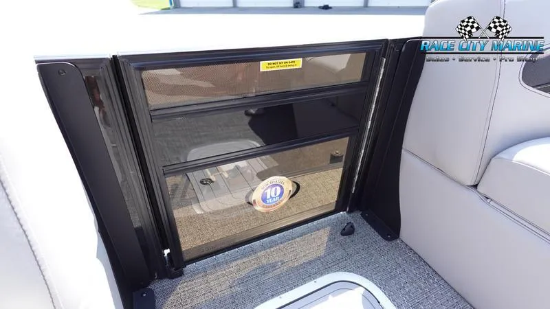 Slide: The Image of 2025 Barletta X23UC boat interior with storage compartment and Race City Marine logo. - 35