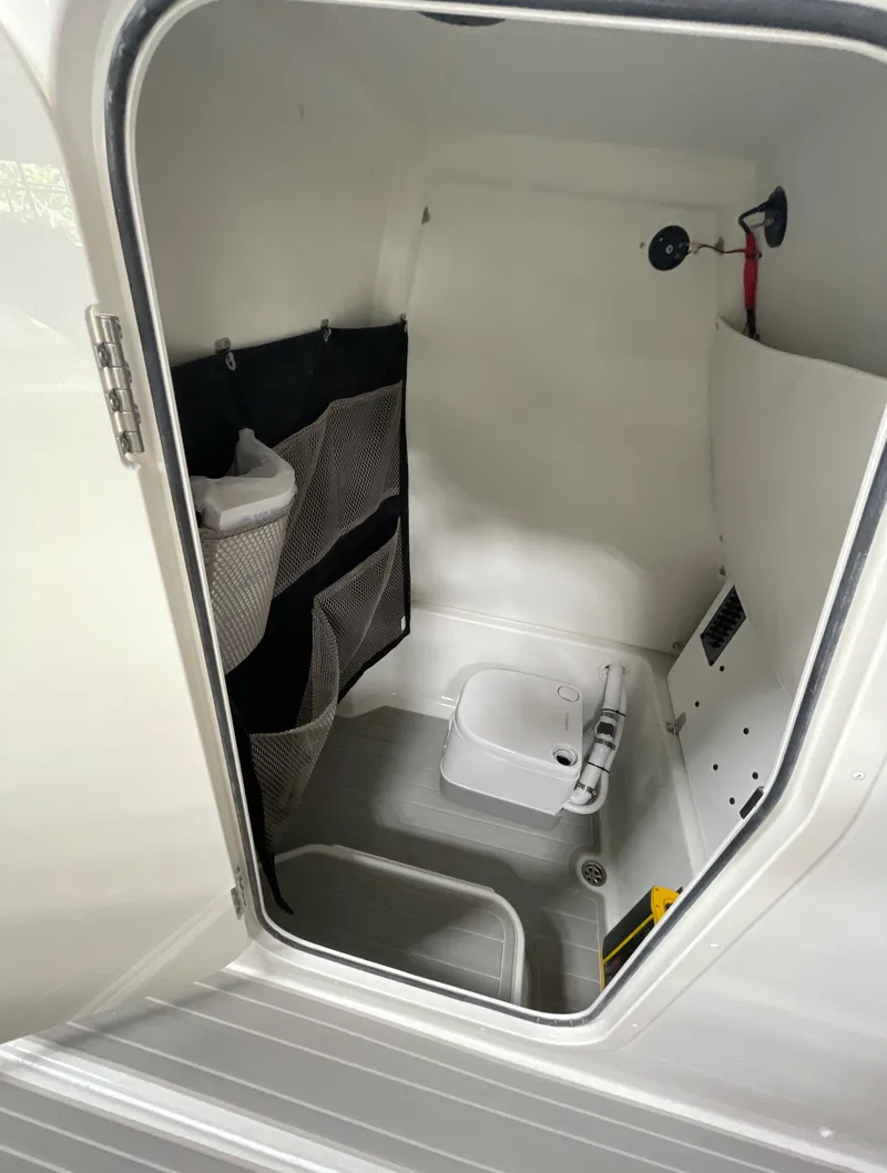 Slide: The Image of 2025 Parker 2600 Center Console boat interior with storage compartments and compact toilet. - 9
