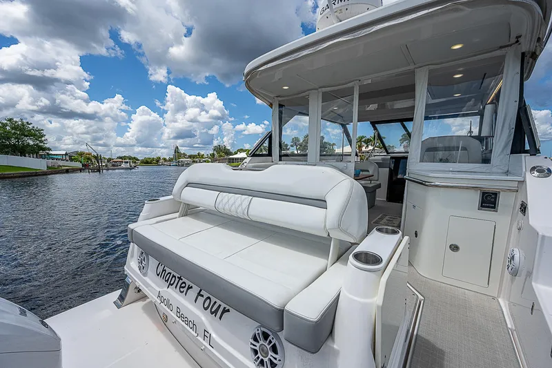 Slide: The Image of 2022 Regal 36 XO yacht on water, featuring spacious seating and modern design. - 23