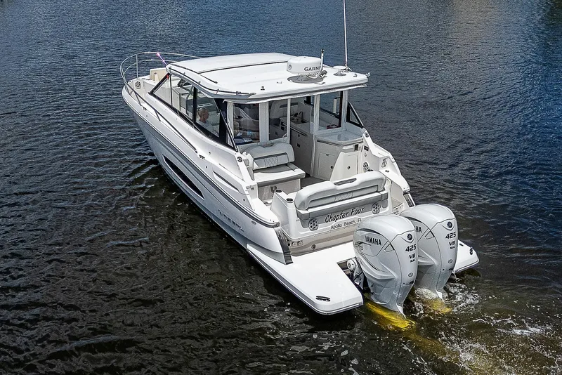 Slide: The Image of 2022 Regal 36 XO boat with dual outboard engines on water. - 39