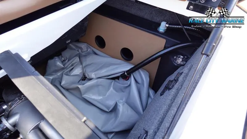Slide: The Image of 2023 Malibu 26 LSV boat storage compartment with ballast bag and Race City Marine logo. - 12