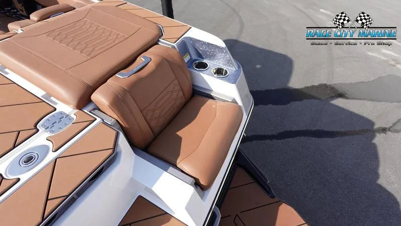 Slide: The Image of 2023 Malibu 26 LSV boat interior with brown seating and cup holders. - 14