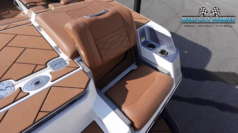 Slide: The Image of 2023 Malibu 26 LSV boat with brown seating and cup holders, Race City Marine logo. - 16