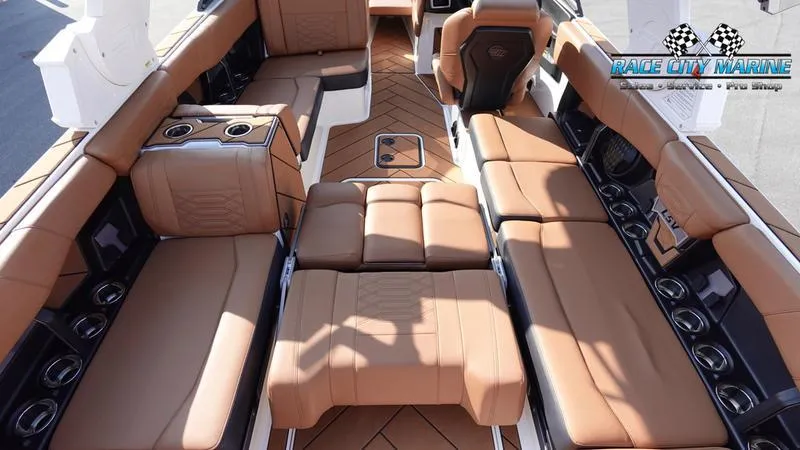 Slide: The Image of 2023 Malibu 26 LSV boat interior with luxurious tan seating and cup holders. - 21