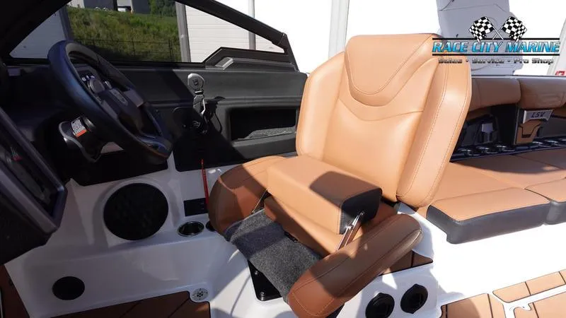 Slide: The Image of 2023 Malibu 26 LSV boat interior with tan leather seating and modern dashboard. - 26