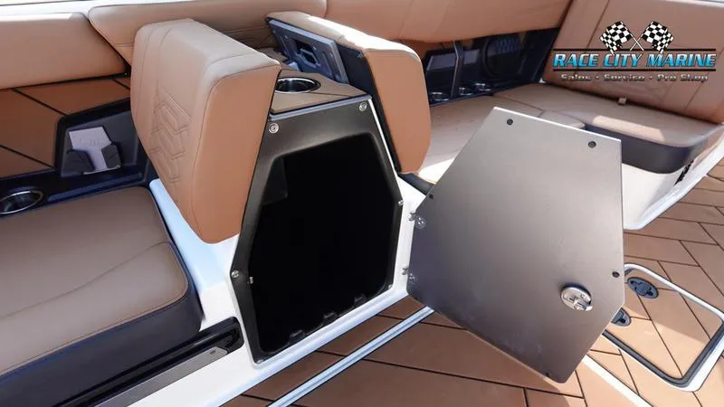 Slide: The Image of 2023 Malibu 26 LSV boat interior with open storage compartment and tan seating. - 36