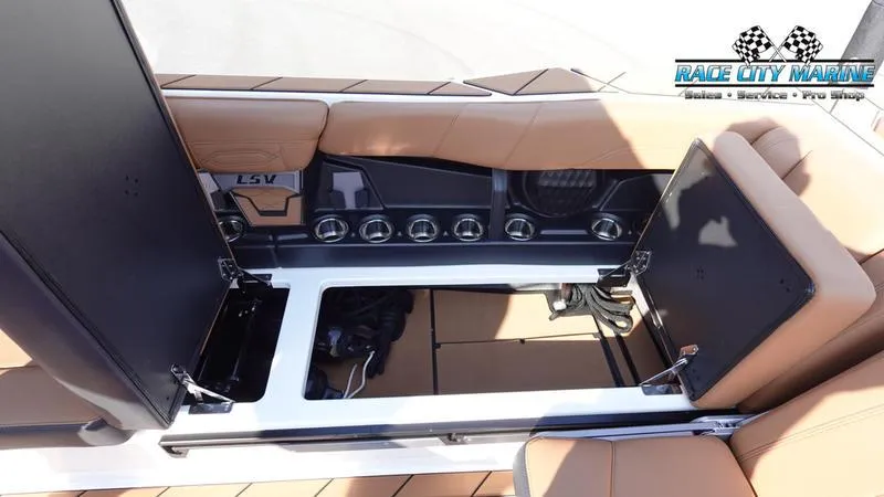 Slide: The Image of 2023 Malibu 26 LSV boat interior with open storage compartments and tan seating. - 41