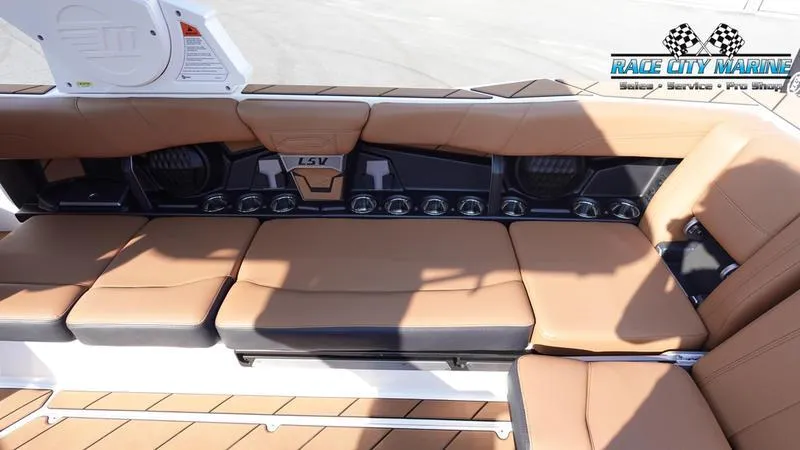 Slide: The Image of 2023 Malibu 26 LSV boat interior with tan seating and Race City Marine logo. - 42