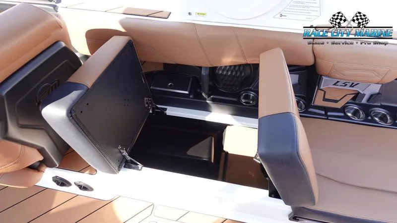 Slide: The Image of 2023 Malibu 26 LSV boat interior with open storage compartments and tan seating. - 43