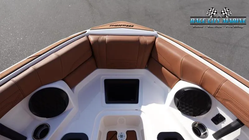 Slide: The Image of 2023 Malibu 26 LSV boat interior with brown leather seating and speakers. - 46