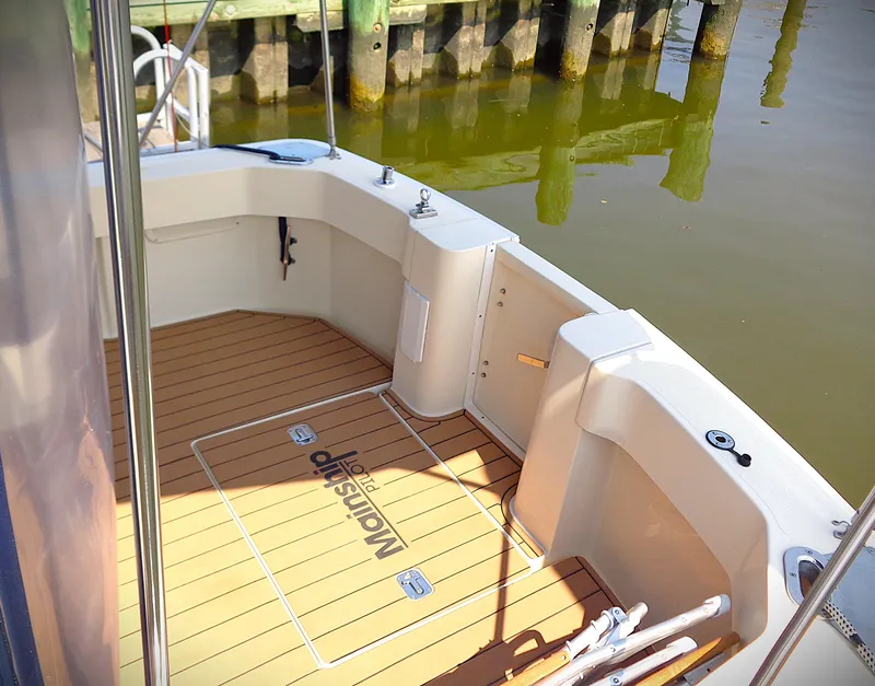 Slide: The Image of 2005 Mainship Pilot 30 Rum Runner II boat deck with teak flooring and dock view. - 11