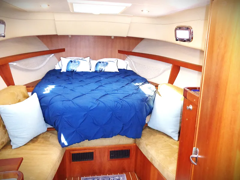 Slide: The Image of Cozy cabin interior of 2005 Mainship Pilot 30 Rum Runner II with blue bedding. - 2