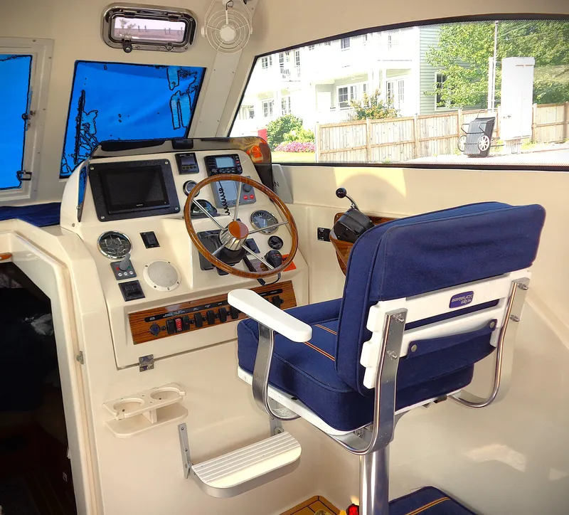 Slide: The Image of 2005 Mainship Pilot 30 Rum Runner II helm with blue captain's chair and navigation instruments. - 9