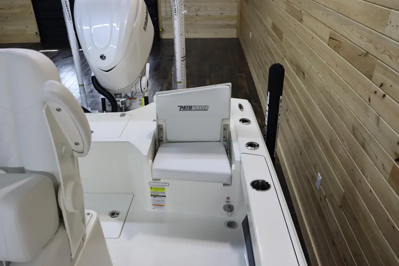 Slide: The Image of 2025 Pathfinder 2500 Hybrid boat interior with seating and motor, in a wooden-paneled showroom. - 11