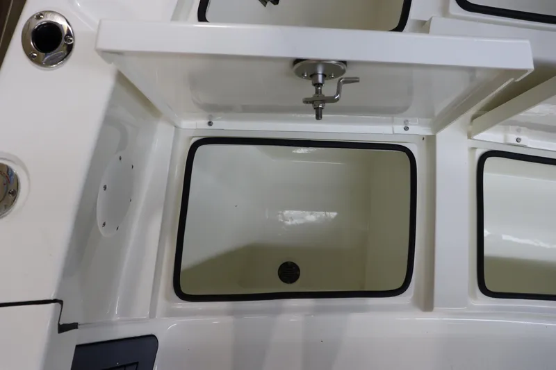Slide: The Image of Pathfinder 2500 Hybrid 2025 boat storage compartment with drain and faucet. - 32
