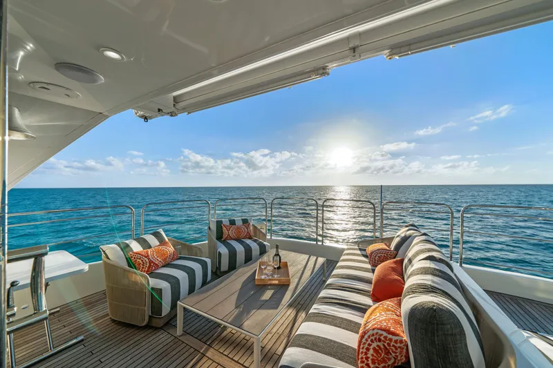 Slide: The Image of Luxurious Sunreef 70 yacht deck with ocean view, striped seating, and sunset ambiance. - 28
