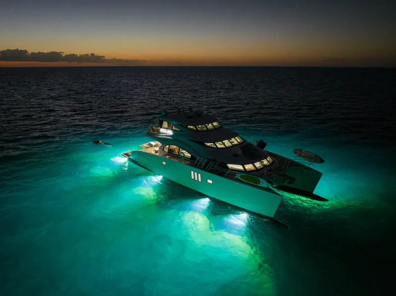 Slide: The Image of Luxurious 2016 Sunreef 70 yacht illuminated at sunset on tranquil ocean waters. - 45