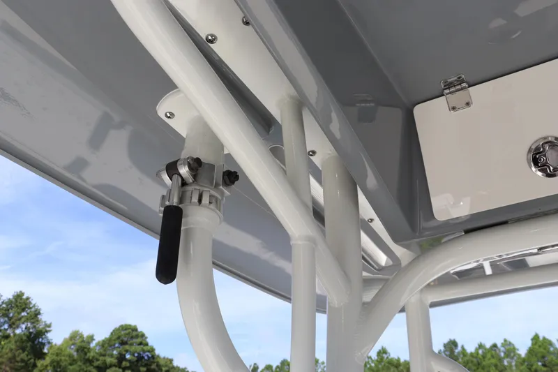 Slide: The Image of 2025 Pathfinder 2700 Open boat detail, showcasing rod holders and storage against a clear sky. - 24