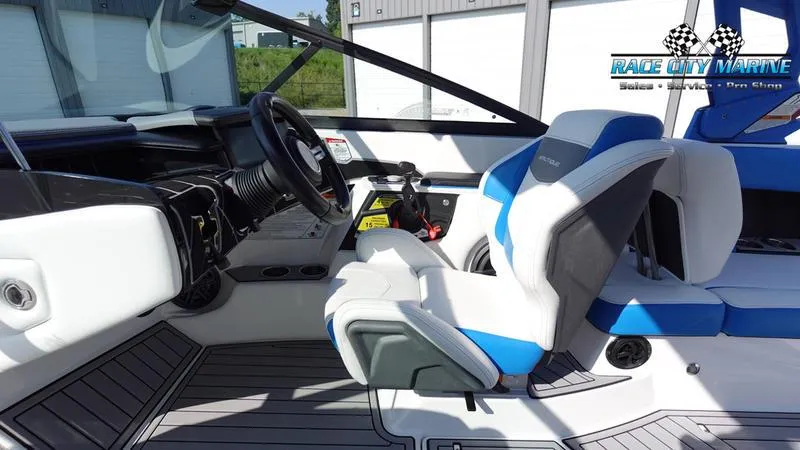 Slide: The Image of 2019 Nautique Super Air Nautique 230 interior with blue and white seating, Race City Marine logo. - 17