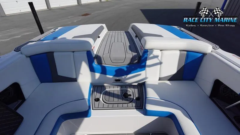 Slide: The Image of 2019 Nautique Super Air Nautique 230 interior with blue and white seating, Race City Marine logo. - 29