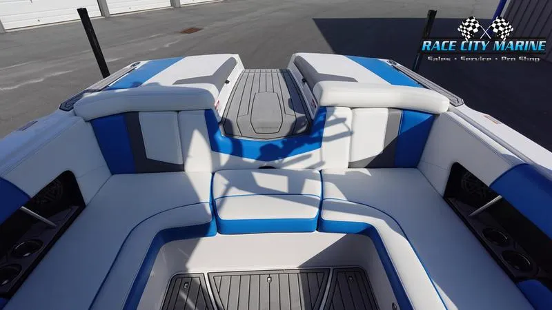 Slide: The Image of 2019 Nautique Super Air Nautique 230 boat interior with blue and white seating. - 32