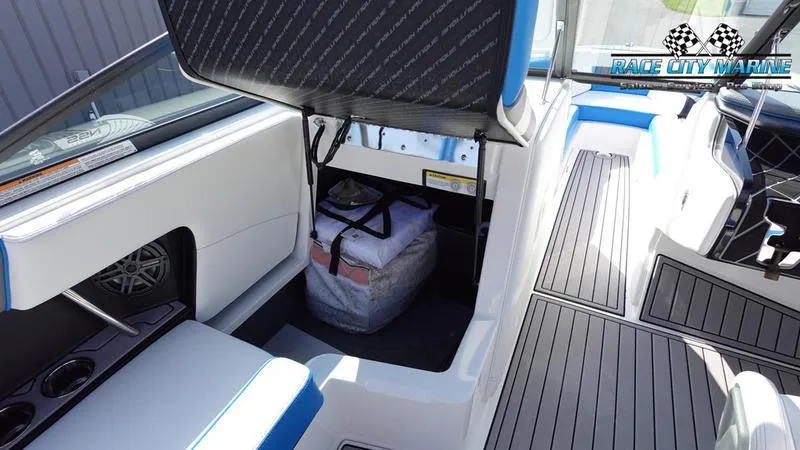 Slide: The Image of 2019 Nautique Super Air Nautique 230 interior storage compartment with open seat and visible gear. - 34