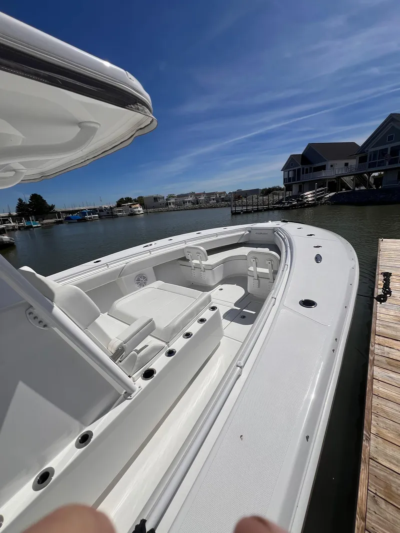 Slide: The Image of 2024 SeaHunter 35 Tournament boat docked, showcasing spacious deck and seating under clear skies. - 2