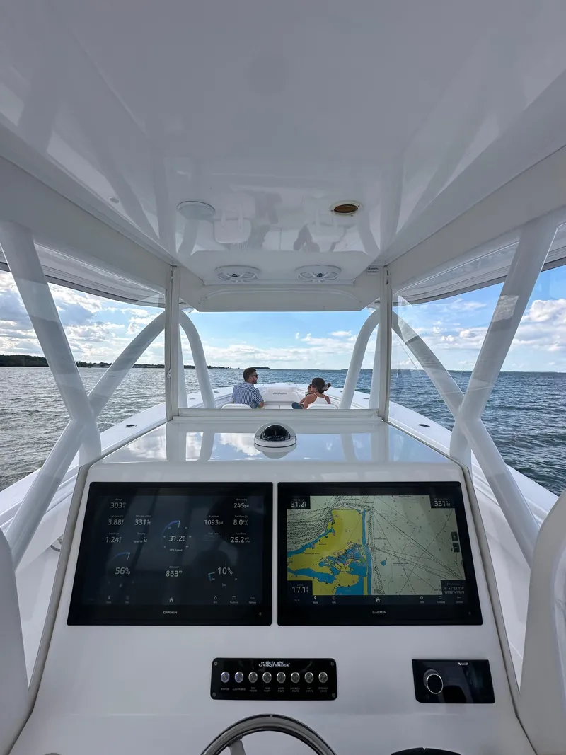 Slide: The Image of 2024 SeaHunter 35 Tournament boat dashboard with navigation screens, ocean view, and passengers. - 25