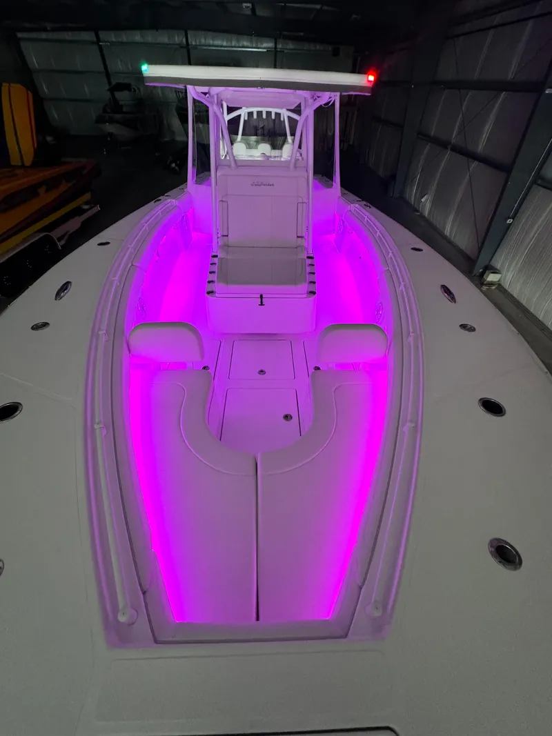 Slide: The Image of 2024 SeaHunter 35 Tournament boat with vibrant pink interior lighting in a dimly lit garage. - 27