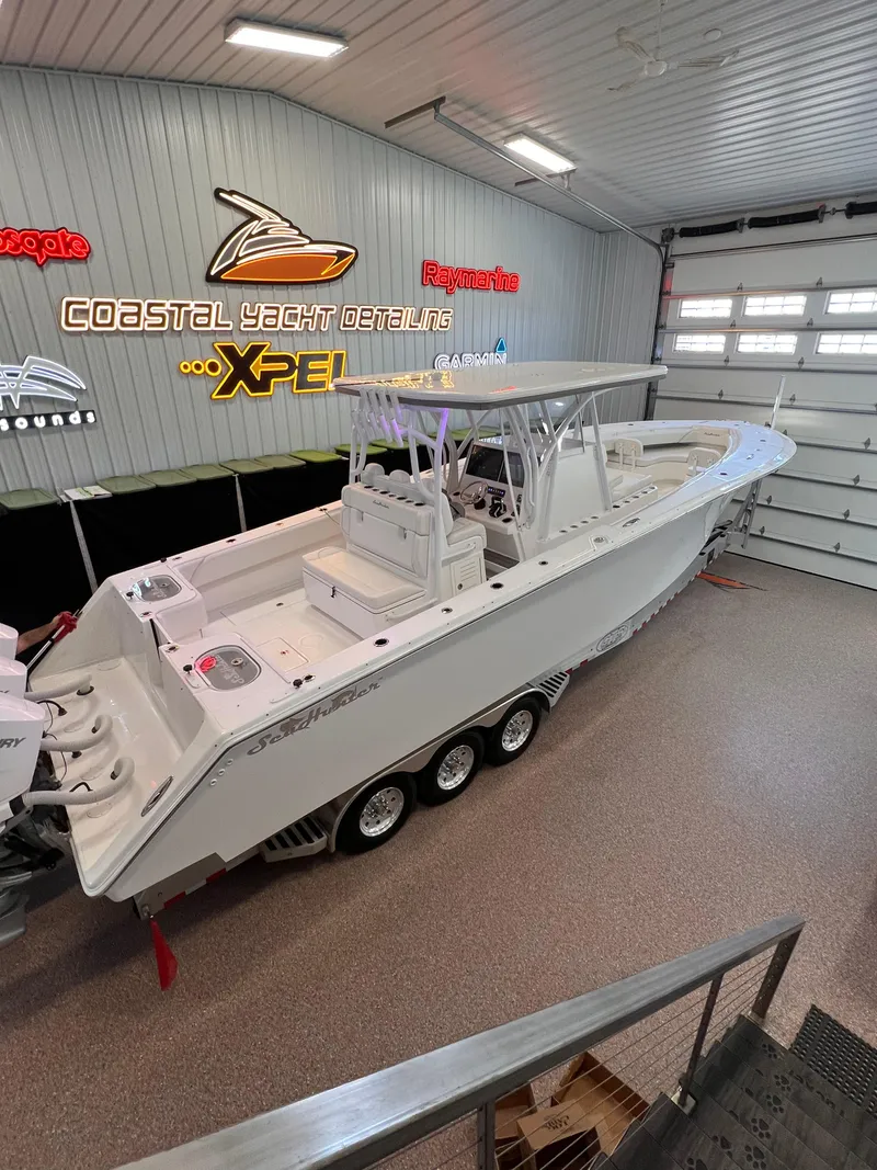 Slide: The Image of 2024 SeaHunter 35 Tournament boat in a detailing garage, showcasing sleek design and triple-axle trailer. - 31